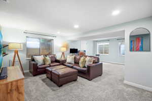 Spacious carpeted room featuring recessed lighting and multiple windows