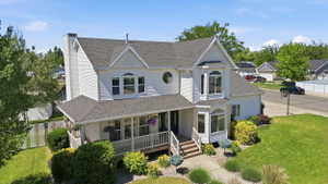 Two-story residence featuring white siding, a covered porch with white railings, and a prominent front entrance with stairs