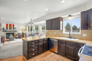 Kitchen featuring dark wood cabinetry, light-toned countertops, and a stainless steel dishwasher