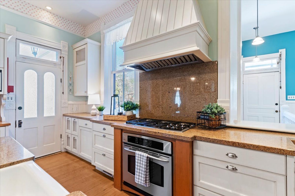 Kitchen featuring a built-in oven, gas cooktop, and custom hood vent