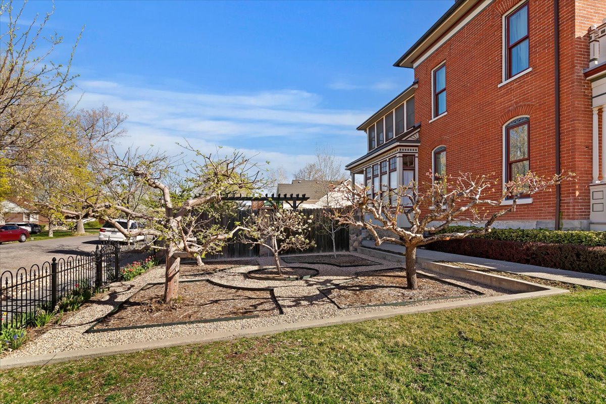 Brick exterior featuring arched window details, a wraparound porch with multiple windows, and decorative trim