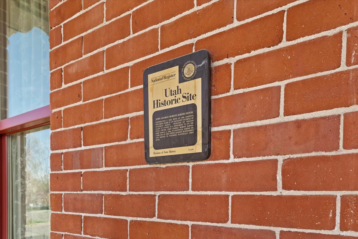 Red brick exterior with white mortar, featuring a historic site plaque
