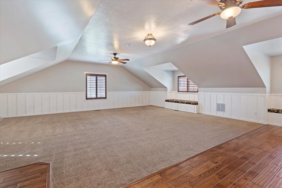 Spacious bonus room featuring sloped ceilings, recessed lighting, and dual ceiling fans