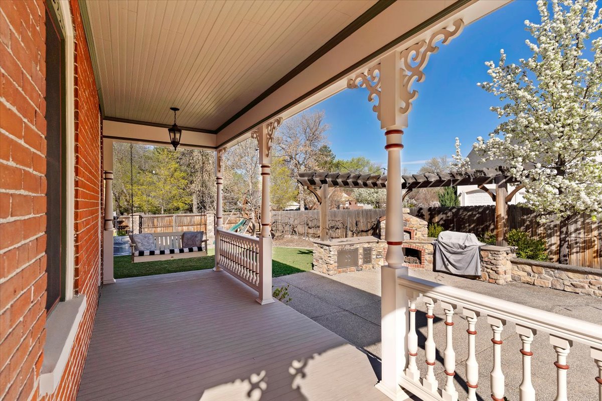 Covered porch with decorative spindle railings and an overhead lantern