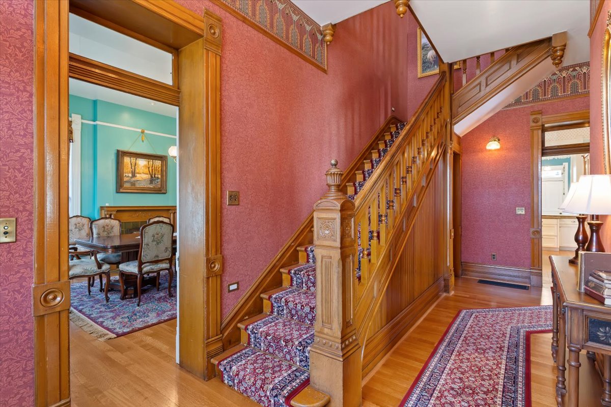 Grand wooden staircase featuring carved newel posts and balusters