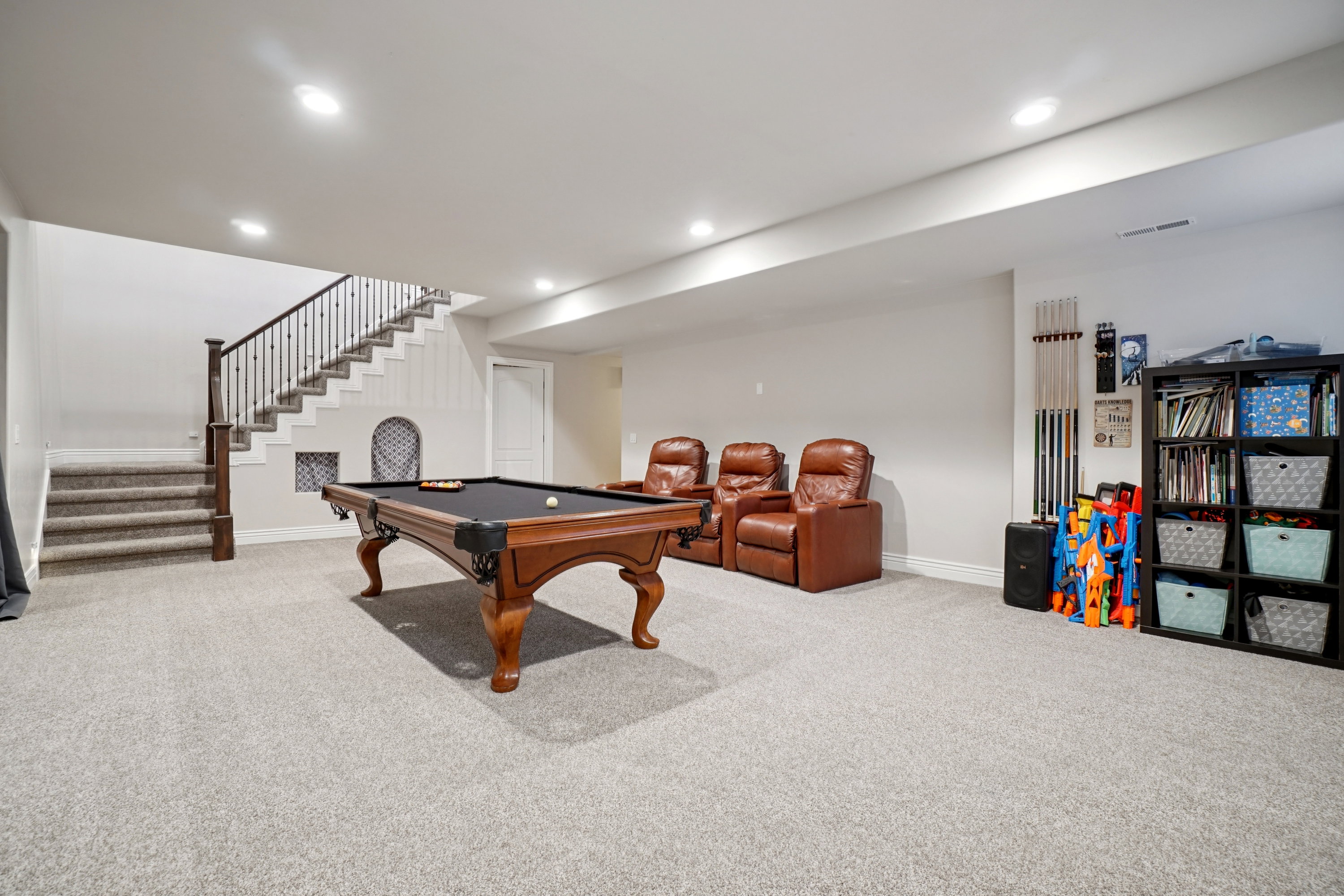 Spacious recreation area featuring light-toned carpeting and recessed lighting