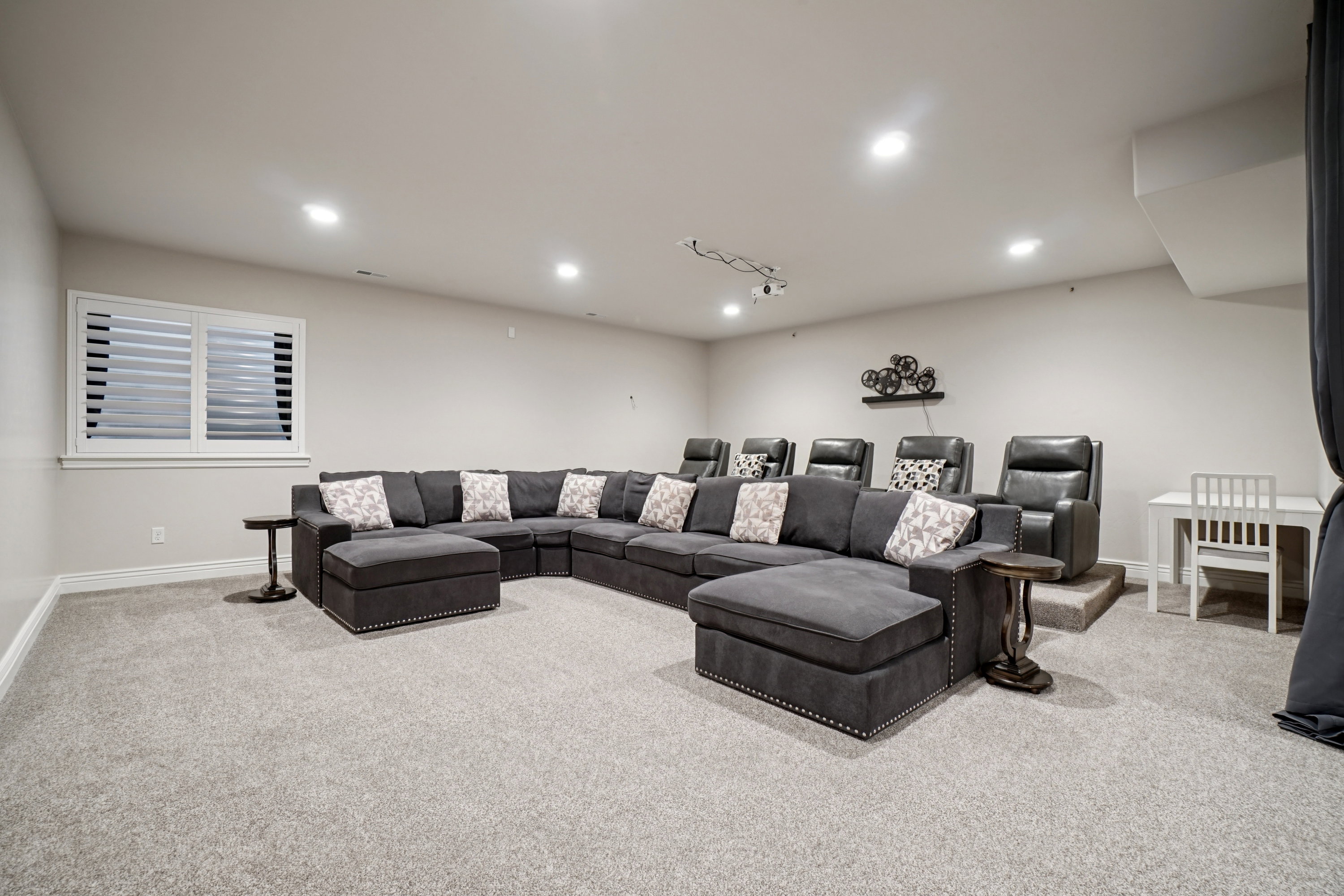 Carpeted room featuring recessed lighting and a window with white louvered shutters
