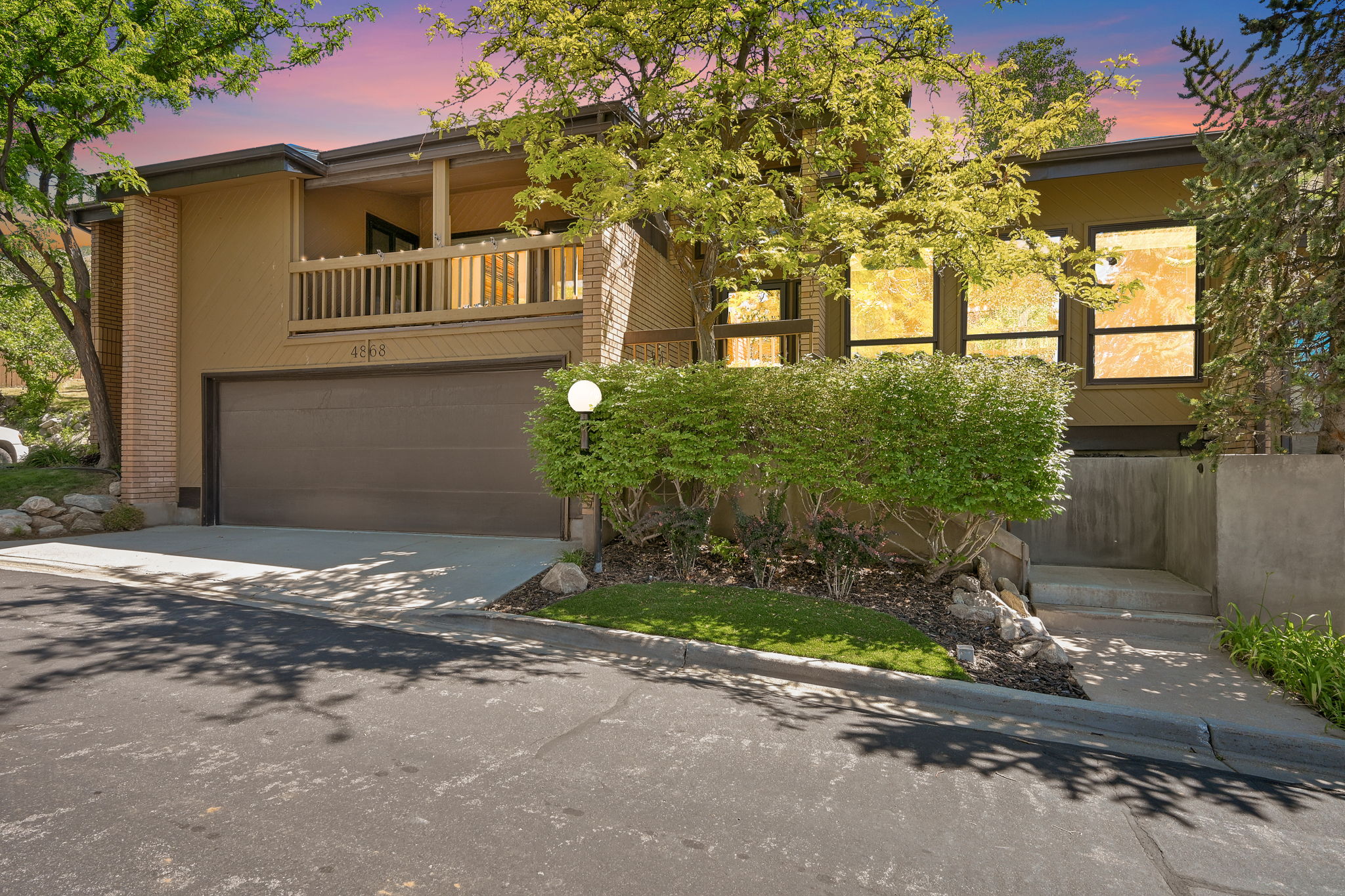 Exterior features a multi-level design with a beige stucco finish and brick accents