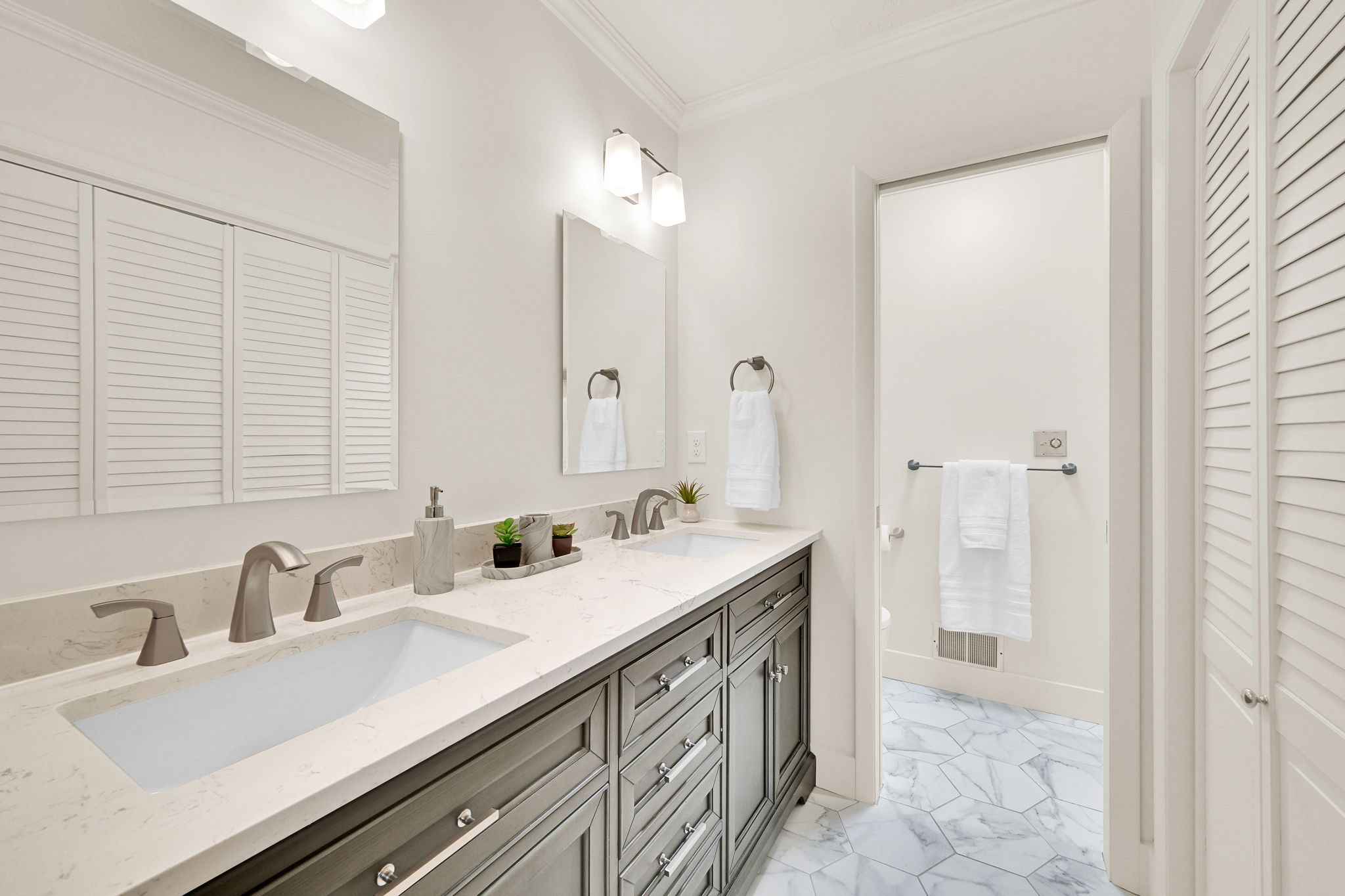 Dual vanity with light-toned countertop, undermount sinks, and brushed nickel fixtures
