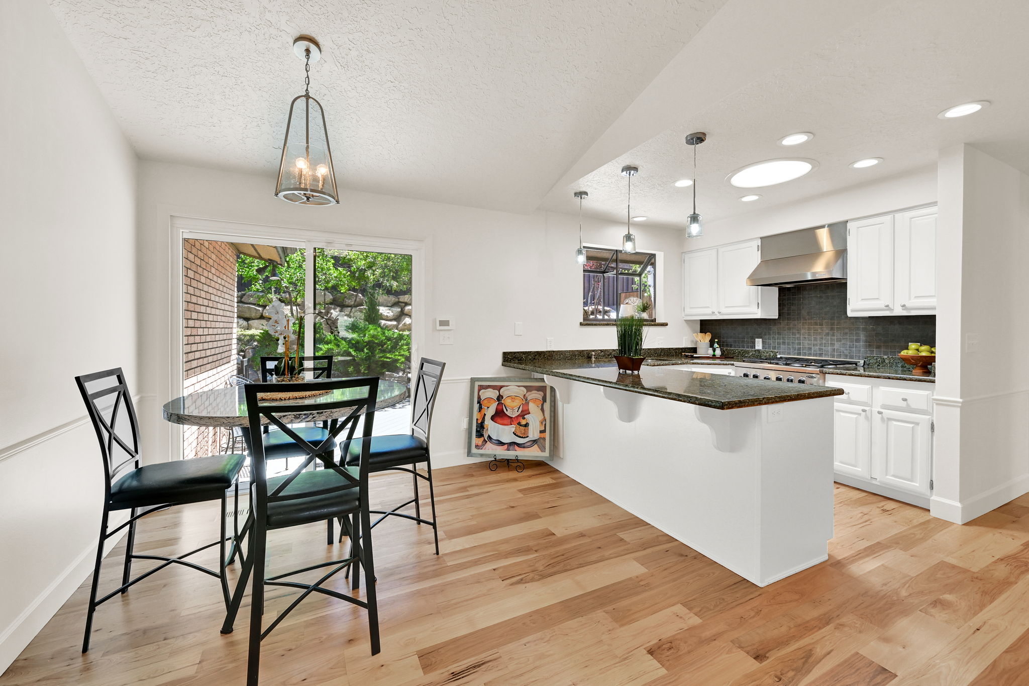Open-concept kitchen and dining area with wood-finish flooring