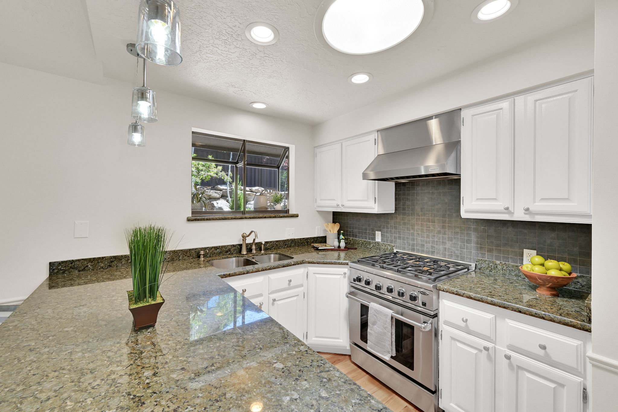 Kitchen featuring white cabinetry, granite countertops, stainless steel range with hood, a tile backsplash, and recessed lighting