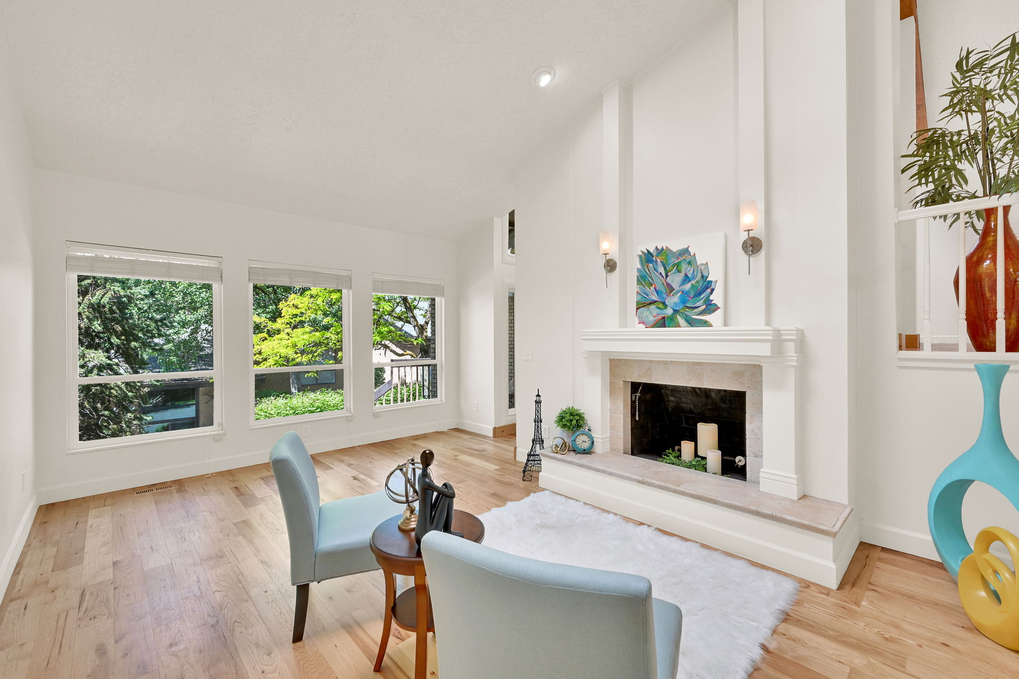 Living area featuring a floor-to-ceiling fireplace with stone surround, wall sconces, and a classic mantel