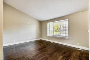 Spacious room with vaulted ceilings and wood-finish flooring