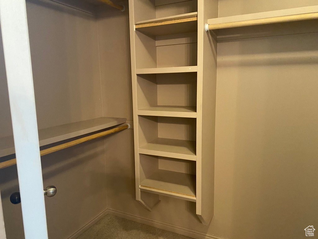 Primary Closet: Custom Built-in shelving unit providing five levels of storage, complemented by a hanging rod and a high shelf