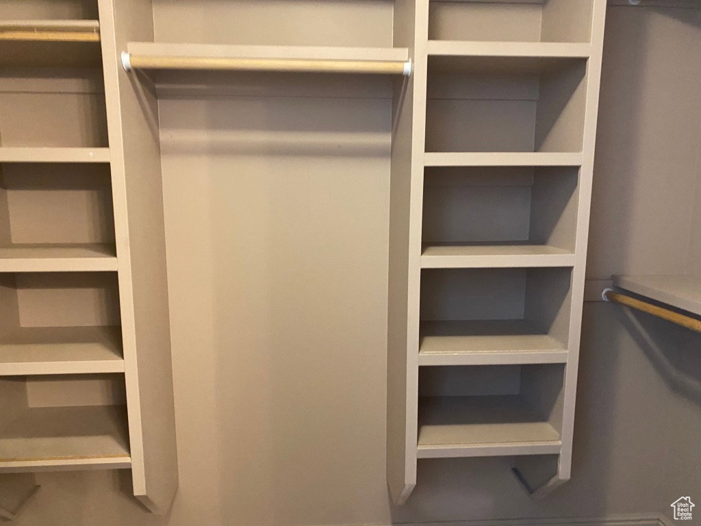 Primary Closet: Custom Integrated shelving system featuring multiple storage compartments and hanging rods