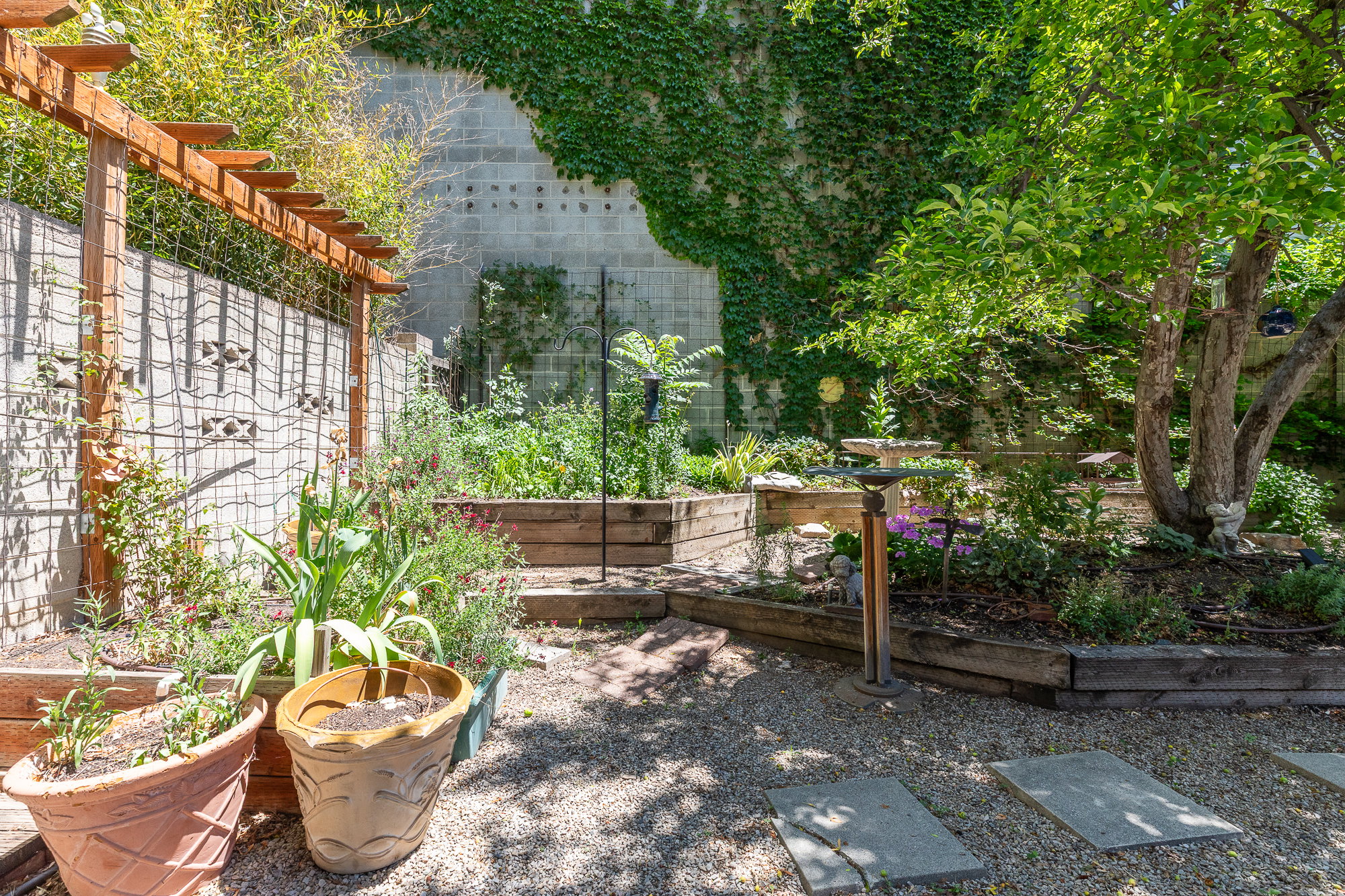 Gravel patio with stepping stones and raised garden beds