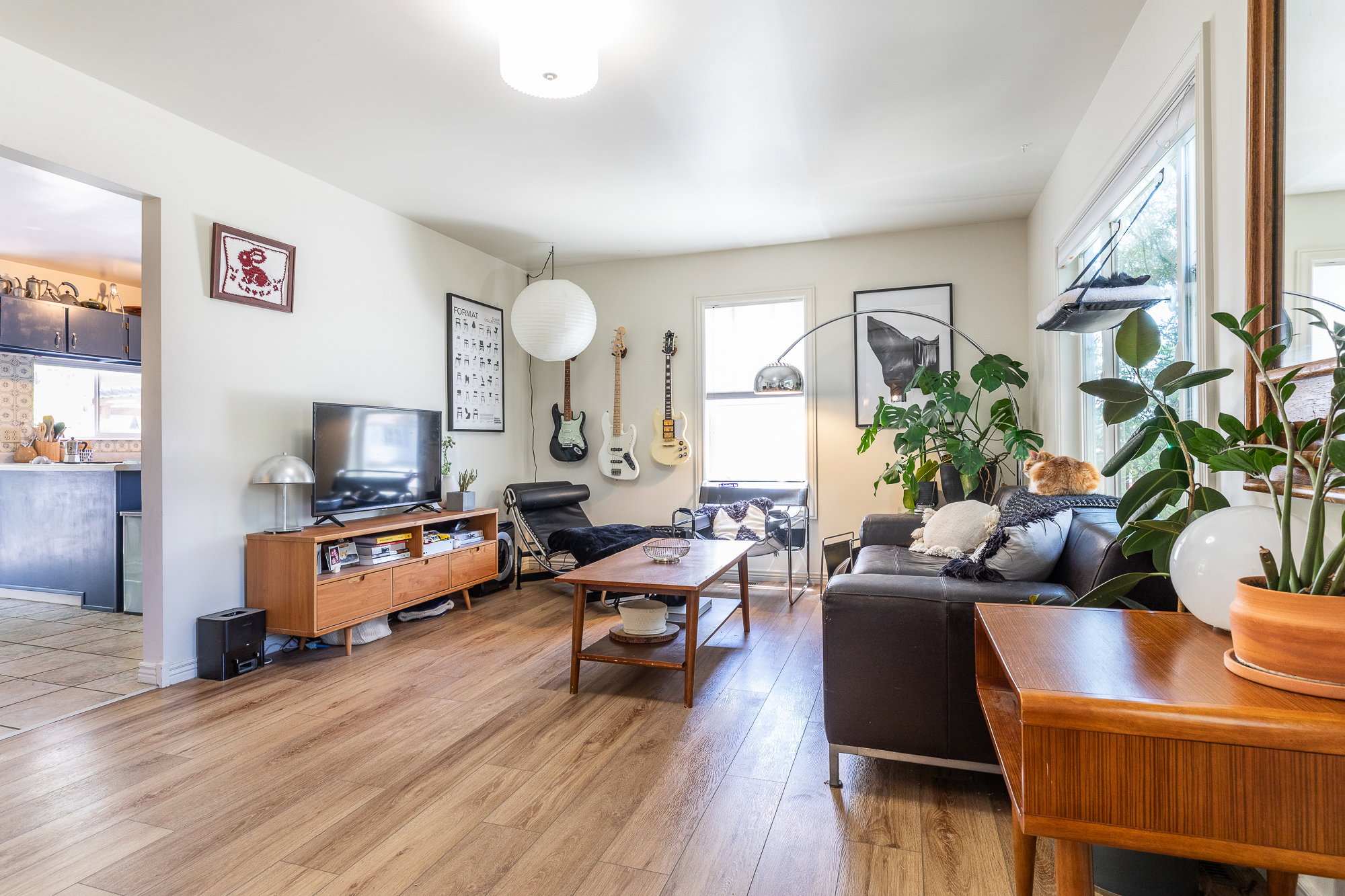 Open concept living space featuring wood-finish flooring, white walls, and a ceiling-mounted light fixture
