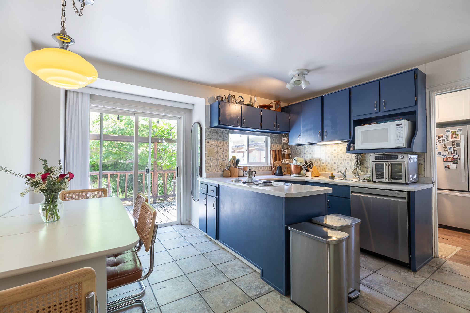 Kitchen featuring blue cabinetry, white countertops, tile flooring, and stainless steel appliances