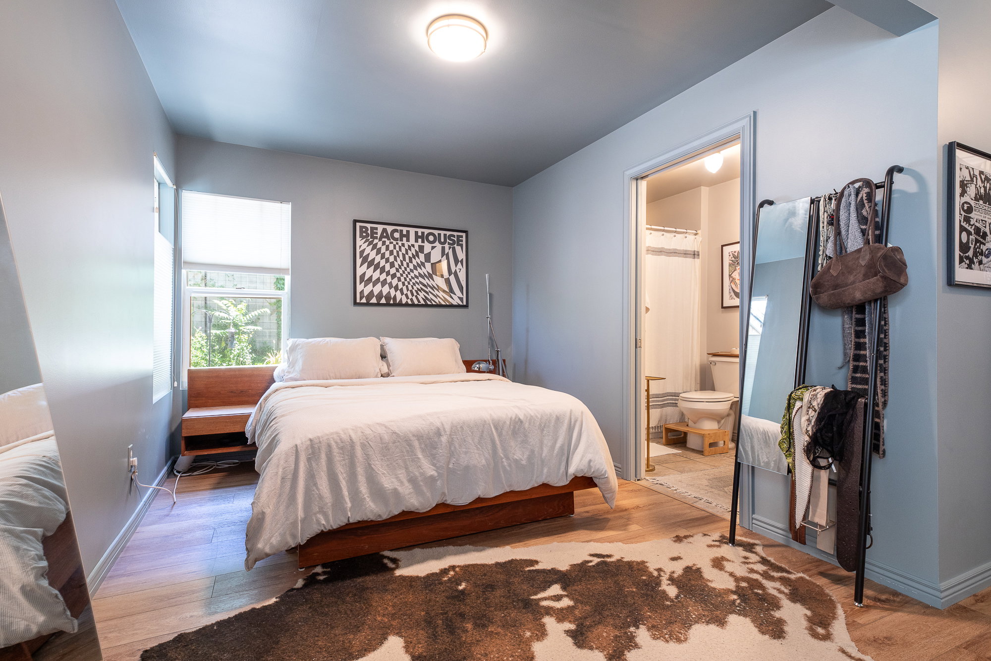 Spacious room featuring wood-finish flooring, a built-in wood bench with storage, and a bright window