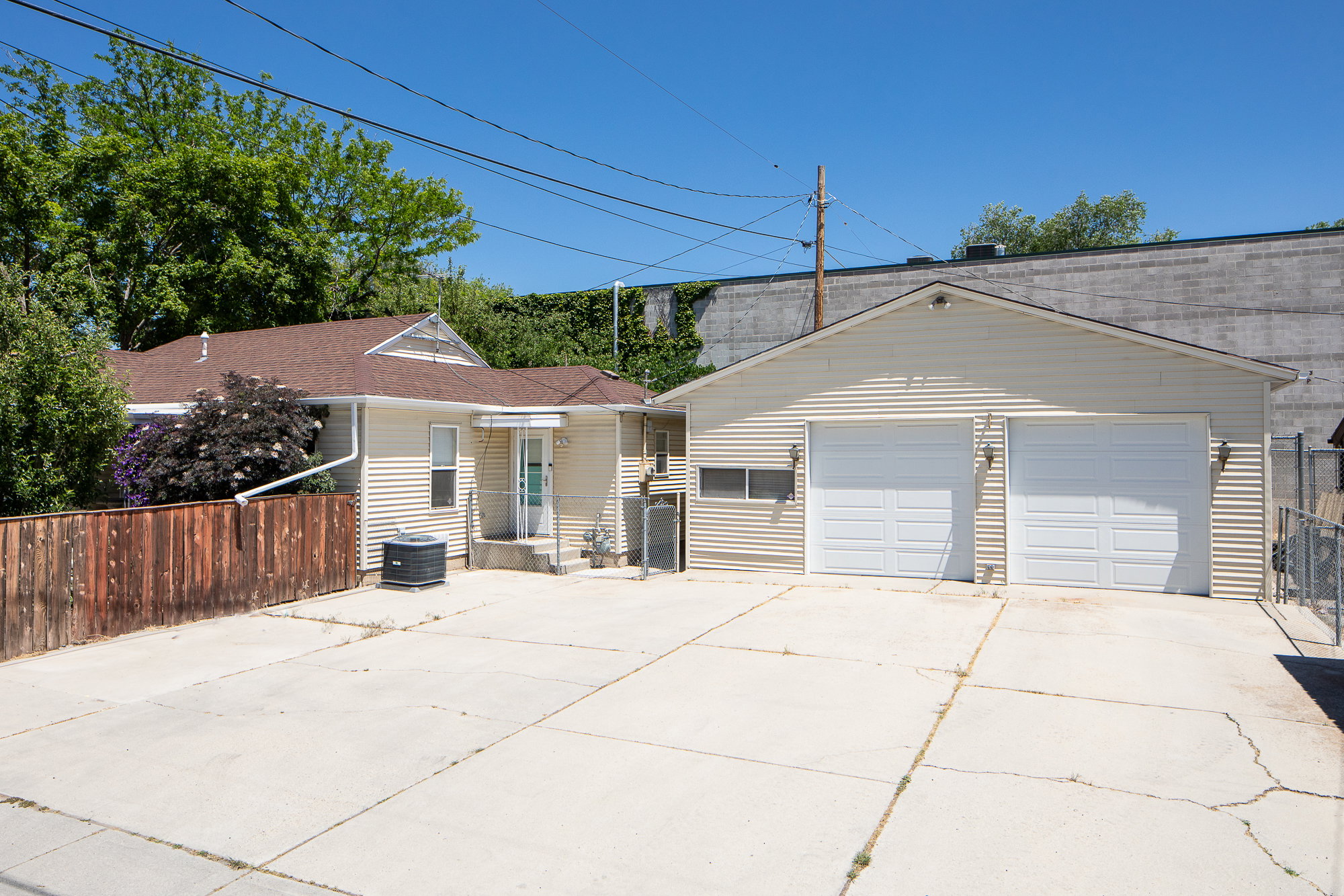 Two-car garage with white paneled doors, accompanied by a spacious concrete driveway