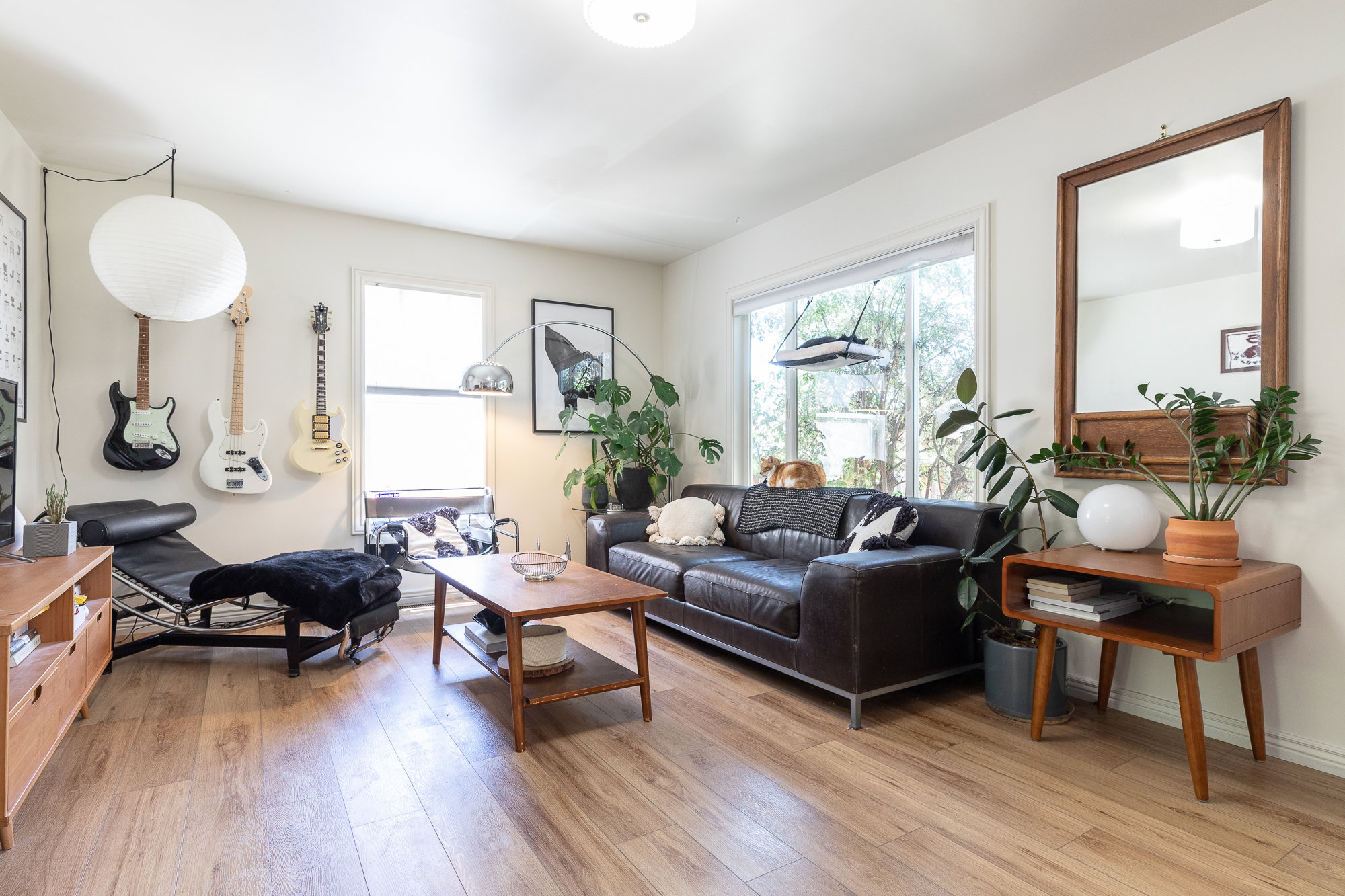 Living space featuring wood-finish flooring, white walls, and abundant natural light from multiple windows