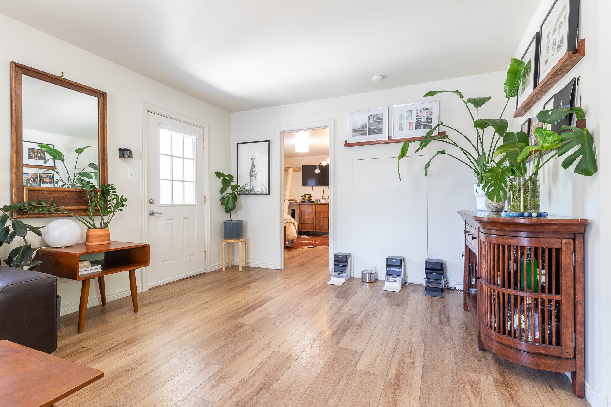 Bright interior space featuring wood-finish flooring, white walls, and a white paneled entry door with glass inserts