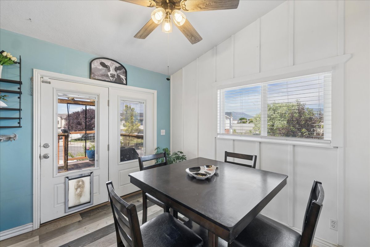 Vaulted ceiling dining area featuring wood-finish flooring and a ceiling fan with light fixture