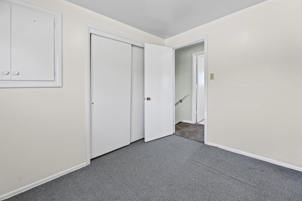 Room with light-colored walls and gray carpet flooring