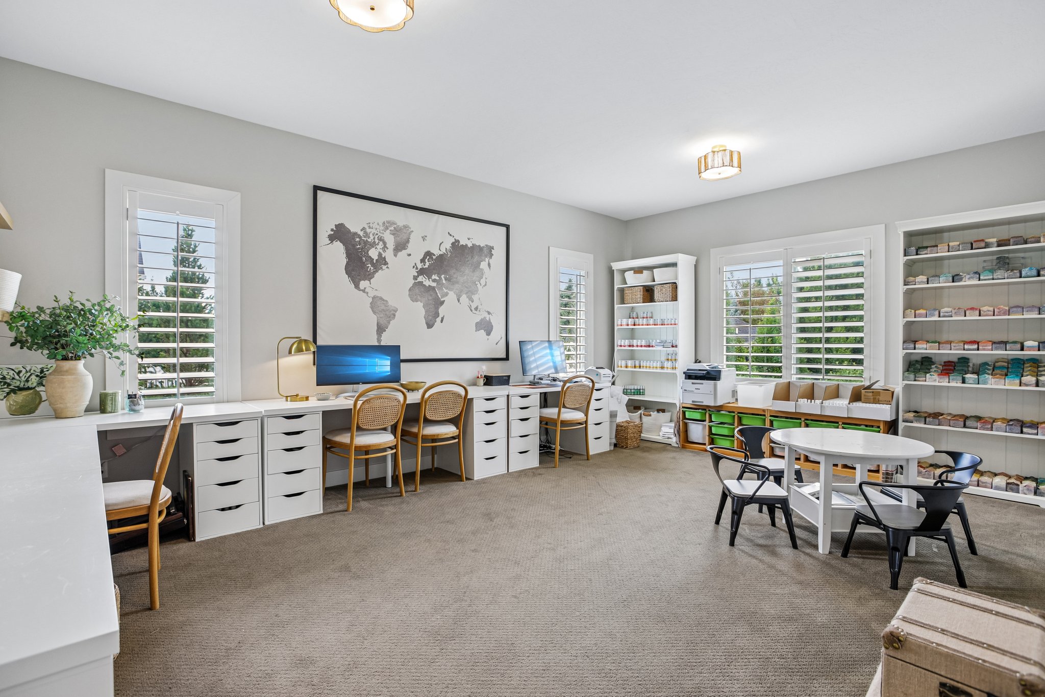 Spacious room featuring multiple large windows with plantation shutters, neutral carpeting, and recessed lighting
