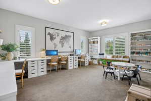 Spacious room featuring multiple large windows with plantation shutters, neutral carpeting, and recessed lighting