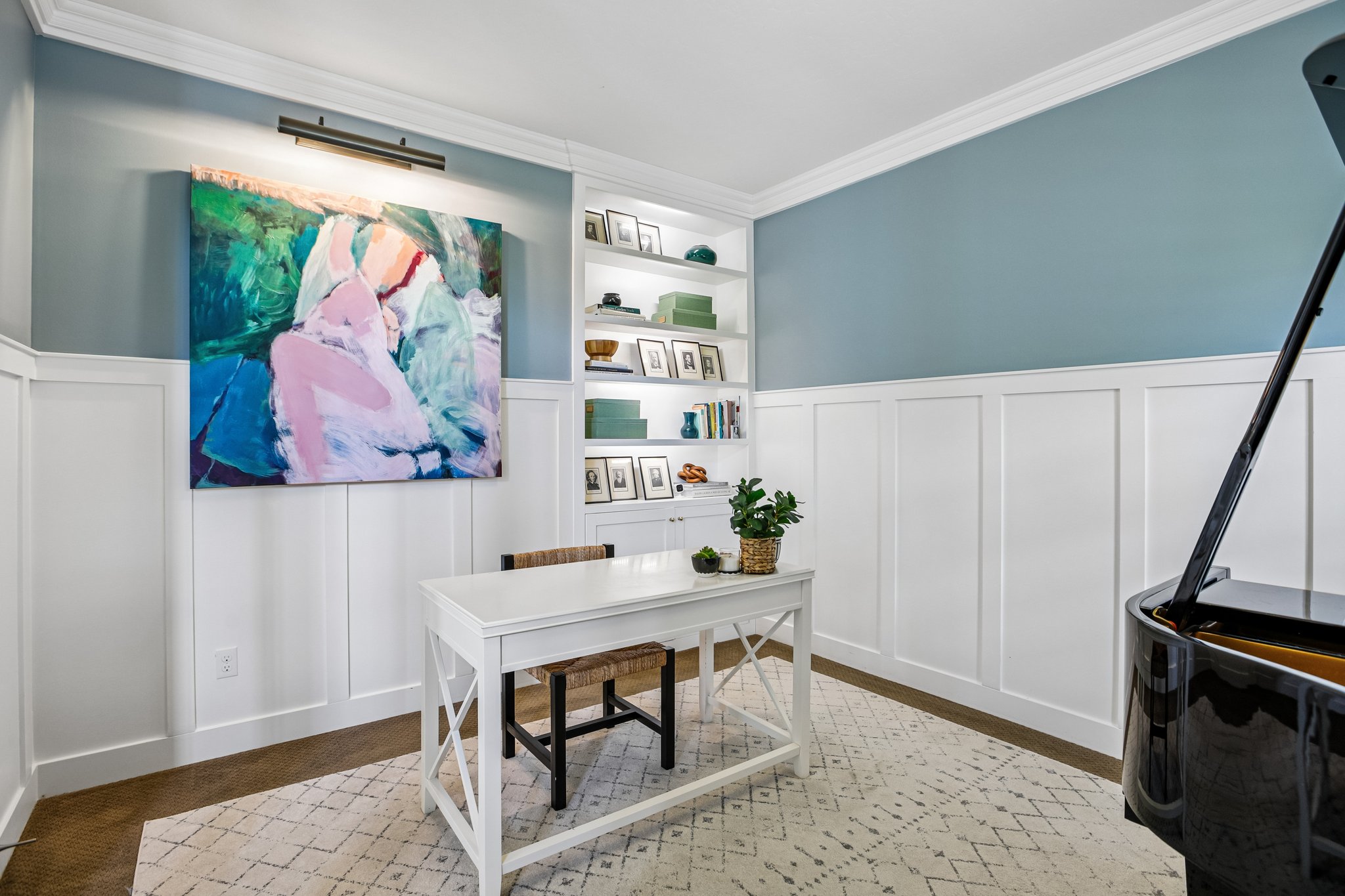 Interior room featuring board and batten paneling, crown molding, a built-in bookcase with integrated lighting, and wood-finish flooring