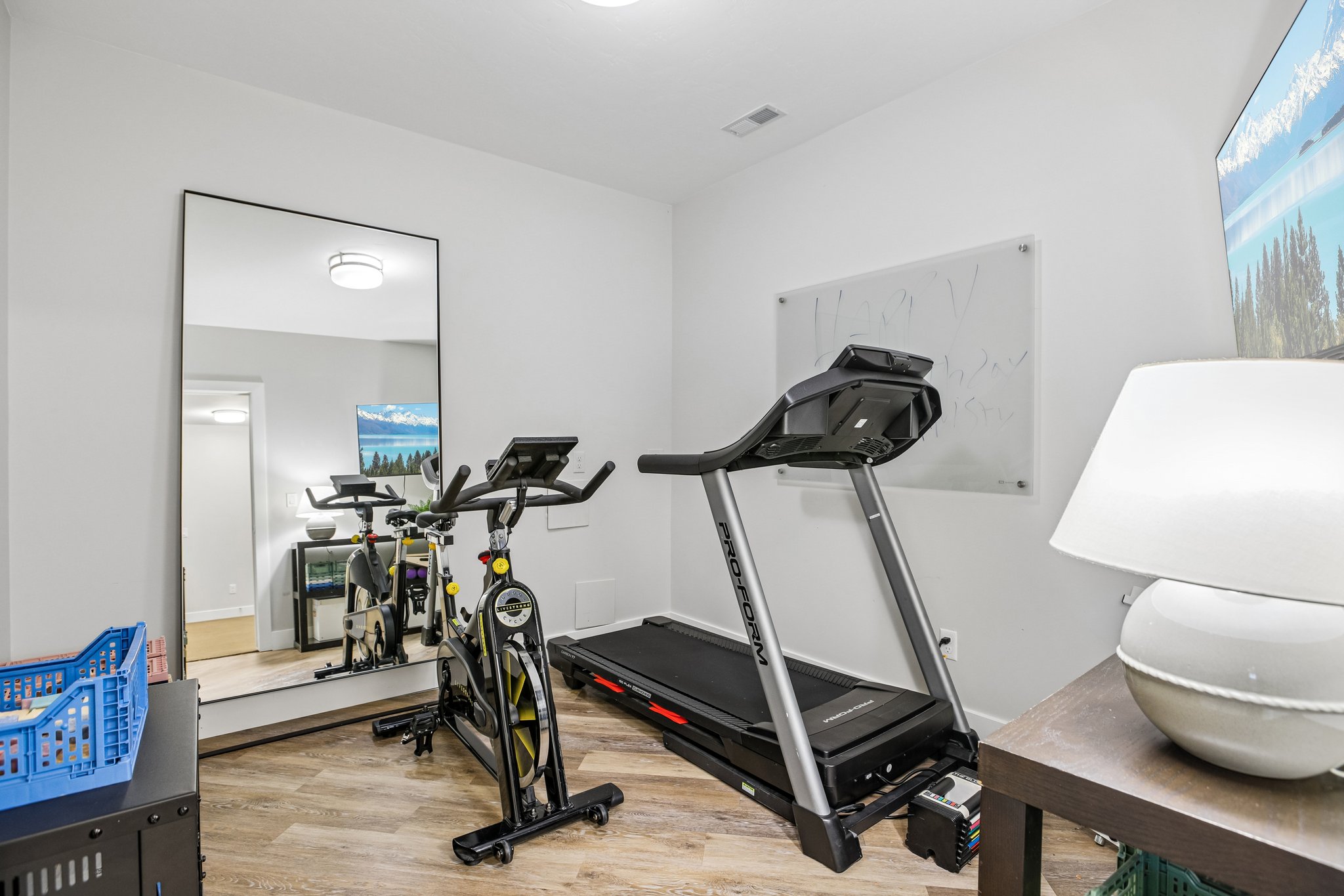 Versatile room featuring wood-finish flooring, recessed lighting, and a full-length mirror