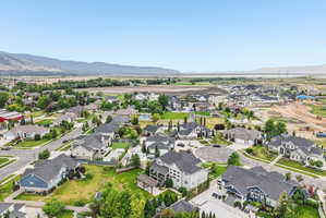 Expansive residential area with a variety of architectural styles, surrounded by green landscapes and distant mountains