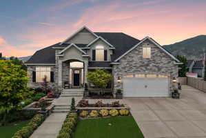 Stone and stucco facade with a covered entry and attached two-car garage