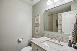 Bathroom vanity with a white rectangular undermount sink, chrome faucet, and a light-toned stone countertop