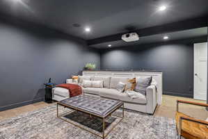 Media room with dark wall color, recessed lighting, and a mounted projector