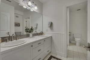 Bathroom vanity featuring dual under-mount sinks, brushed nickel fixtures, and a tile countertop