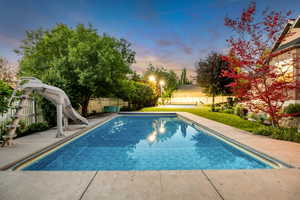 Rectangular inground pool featuring a perimeter of concrete decking