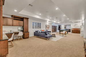 Spacious lower-level area with recessed lighting and neutral carpet flooring