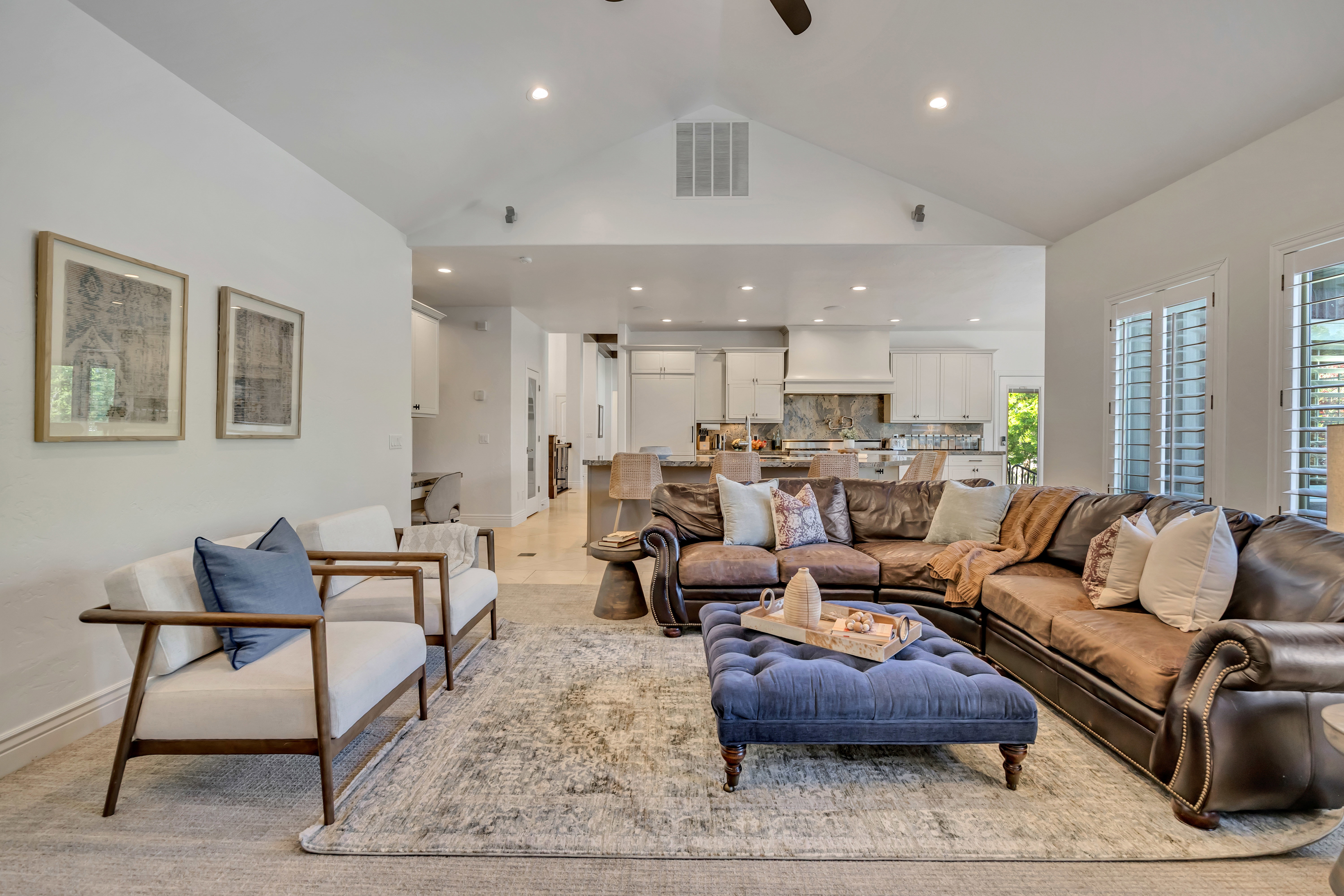 Spacious living area featuring a vaulted ceiling with recessed lighting