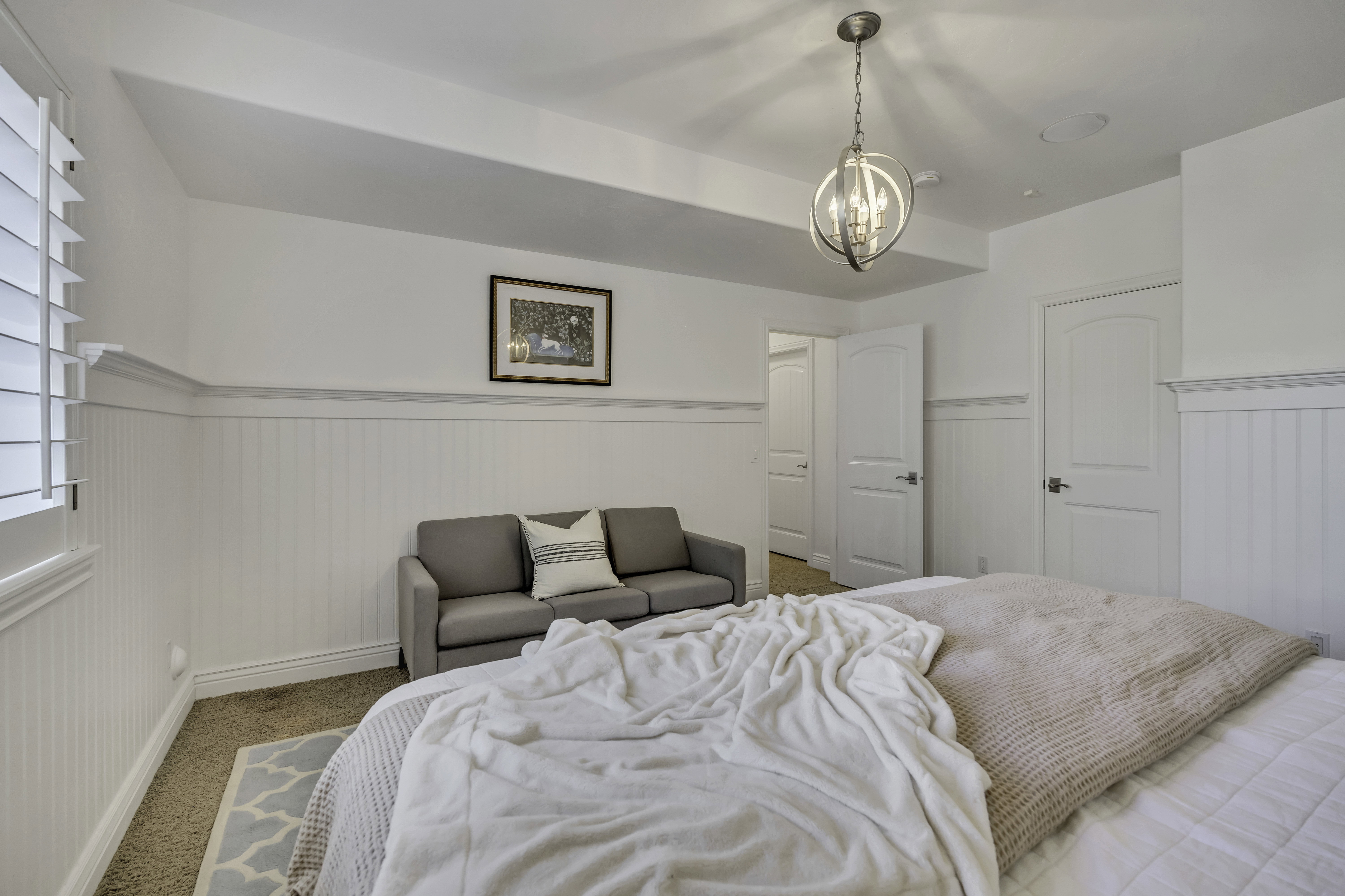 Bright room featuring white wainscoting and plantation shutters
