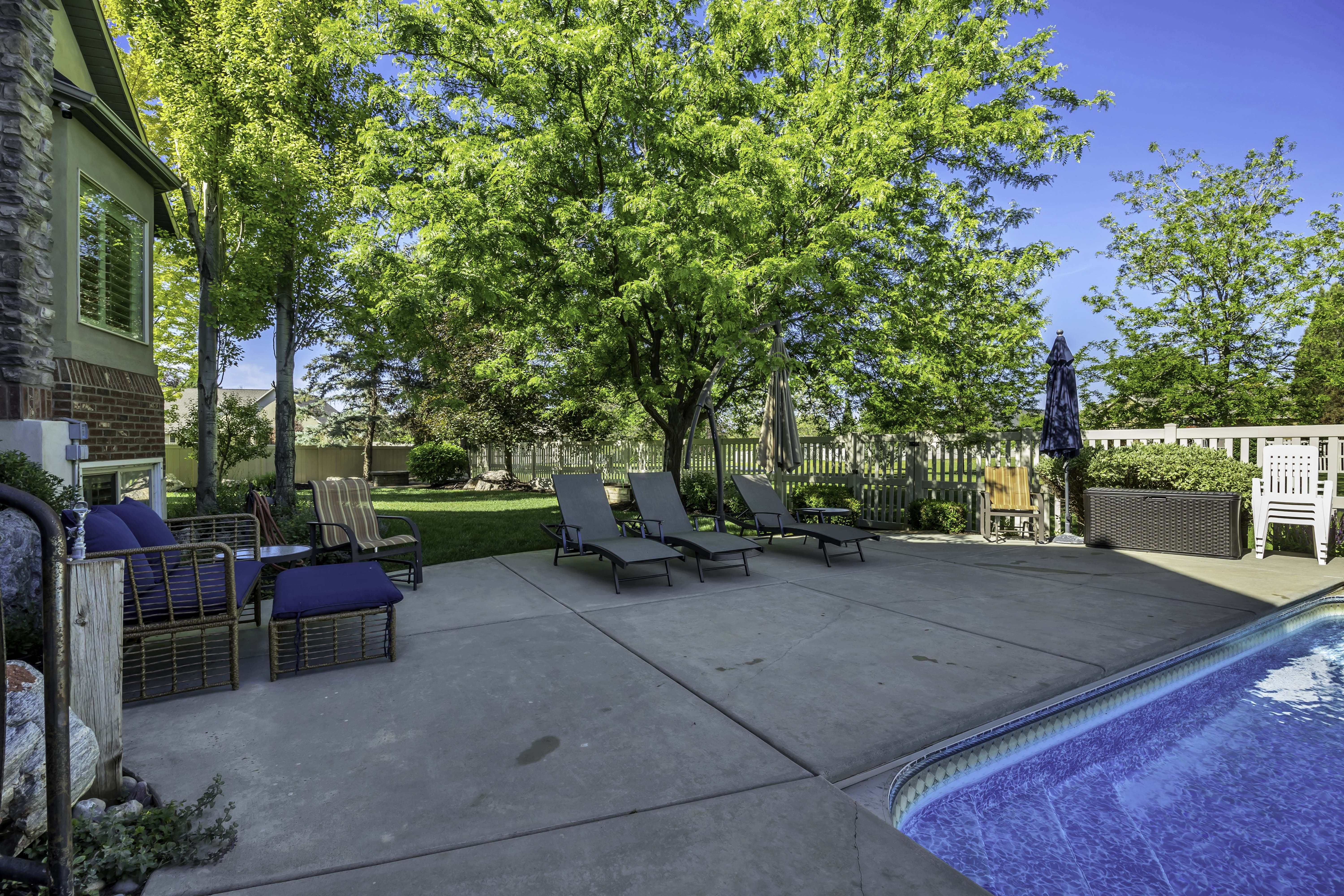 Expansive concrete patio area with an in-ground swimming pool