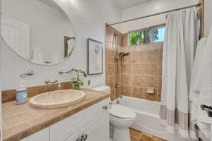 Bathroom featuring a white vanity with an oval vessel sink, wall-mounted faucet, and a large round mirror