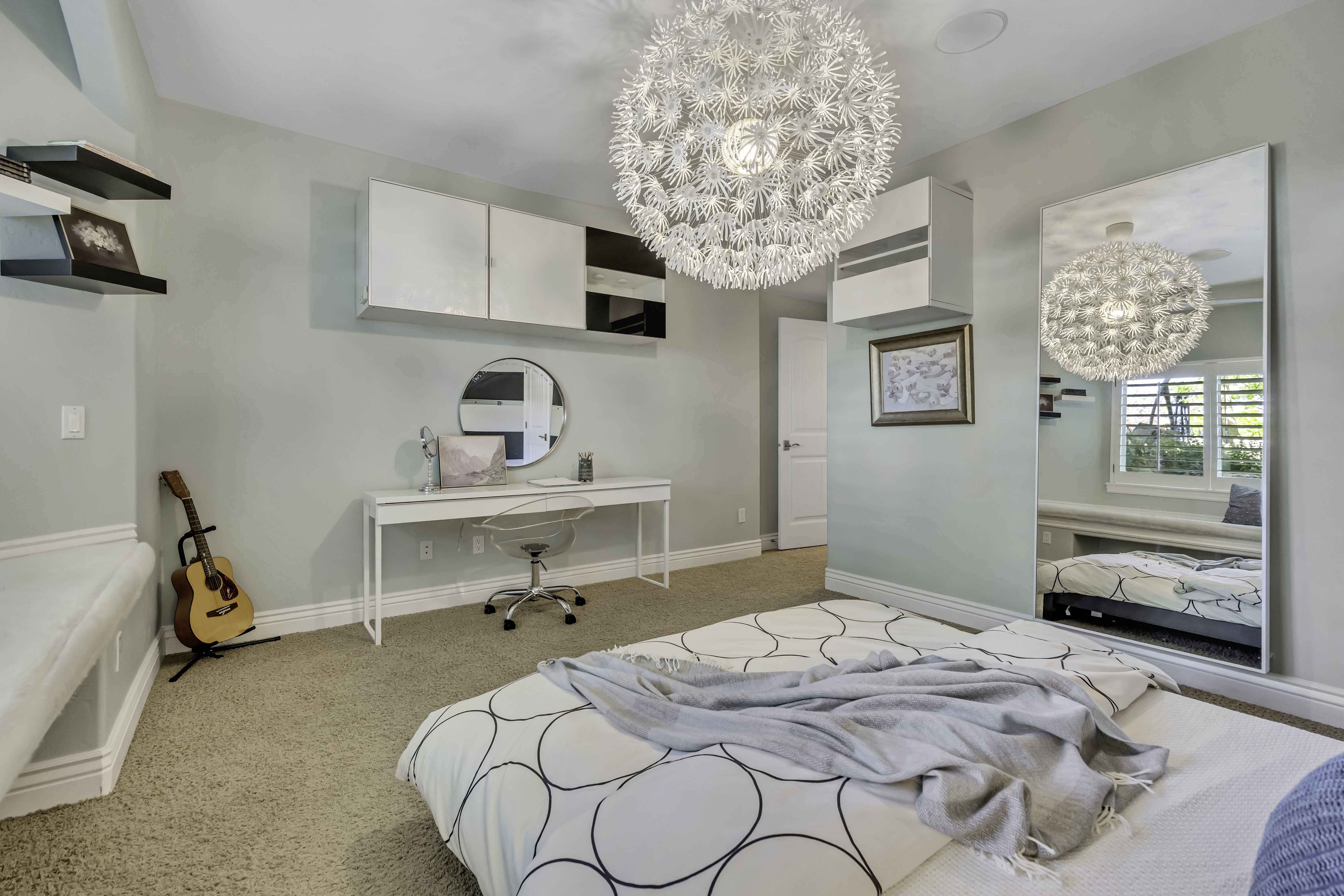 Spacious room featuring neutral carpeting, a large decorative pendant light, and a built-in window bench