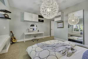 Spacious room featuring neutral carpeting, a large decorative pendant light, and a built-in window bench