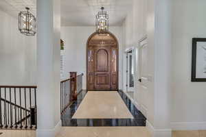 Double-door arched entry featuring decorative glass inserts and rich wood tones