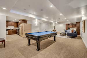 Open-concept lower level featuring recessed lighting, plush carpeting, and a full secondary kitchen with cabinetry and appliances