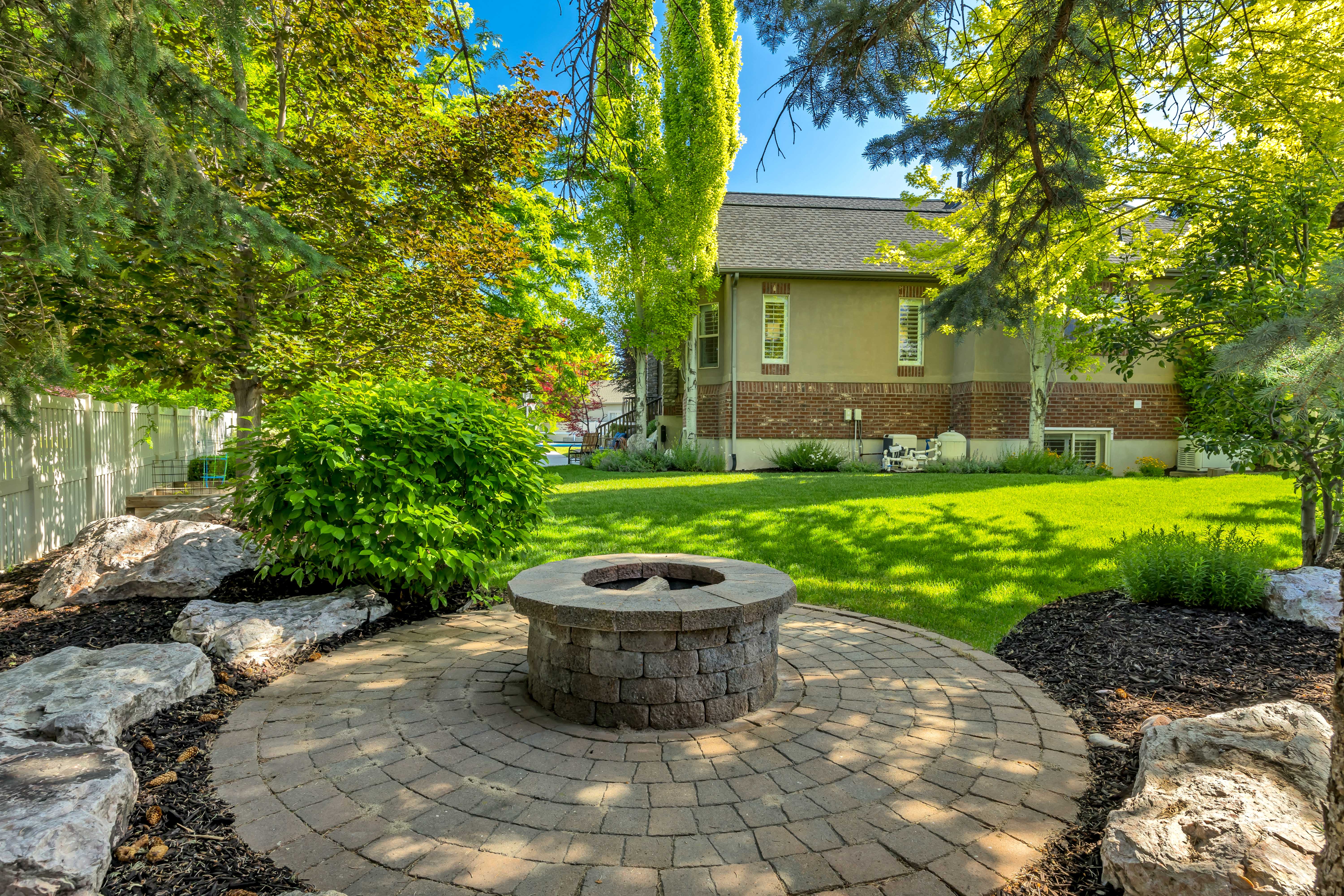 Circular paver patio with a built-in stone fire pit