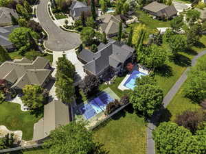Expansive property featuring a swimming pool, tennis court, and manicured lawns with mature trees