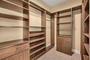 Built-in closet system featuring wood-finish shelving, multiple hanging rods, and integrated drawers with polished hardware